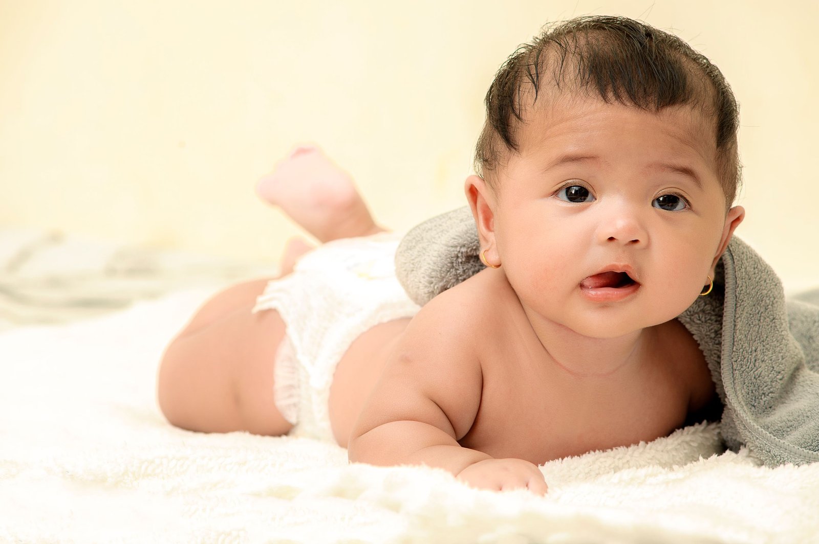 baby with diaper Adorable baby girl lying on soft blankets indoors, showcasing her innocence and cuteness.